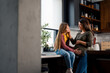 © Dorde - Beautiful smiling pregnant woman and her daughter enjoying while embracing in kitchen at home.