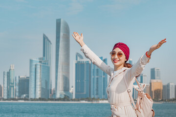 Wall Mural - Experience the joy and wonder of travel, as a happy Asian girl discovers the beauty and excitement of Abu Dhabi.