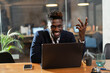 © JustLife - Portrait of successful businessman in office. Young smiling man using the laptop..