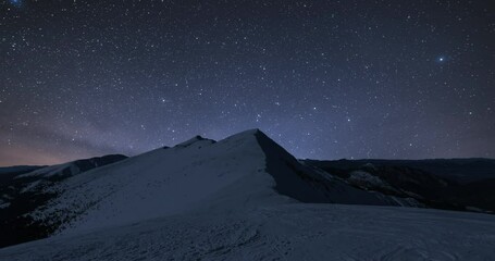 Wall Mural - starry night sky stars milky way galaxy motion fast over winter alps mountains in frozen snowy natur