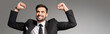 © LIGHTFIELD STUDIOS - successful and overjoyed businessman showing triumph gesture isolated on grey, banner.