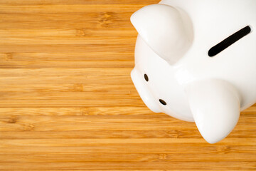 Wall Mural - White ceramic piggy-bank on the light pine wood background