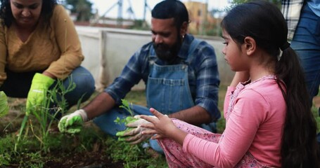 Poster - Indian family having fun gardening together at house organic garden outdoor - Vegetarian, healthy food and education concept 