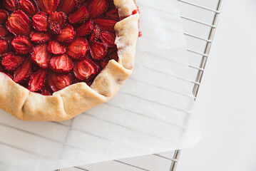 Wall Mural - Homemade strawberry galette pie on baking sheet on white table. Top view