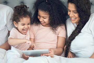 Canvas Print - Our home is filled with laughter. Shot of a beautiful young family talking and bonding in bed together.