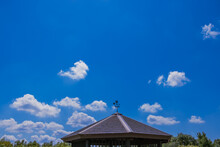 風見鶏のある屋根と青空に浮かぶ白雲