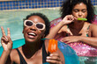 © Meeko Media - Two Black friends pose in the swimming pool eating ice lolly popsicle
