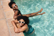 © Meeko Media - Two beautiful Black women cool off in swimming pool, summer heatwave