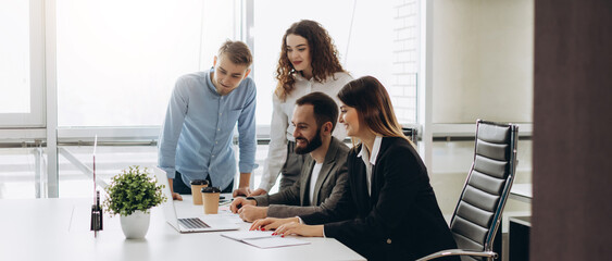 Young coworkers. Young modern colleagues in smart casual wear working while spending time in the office