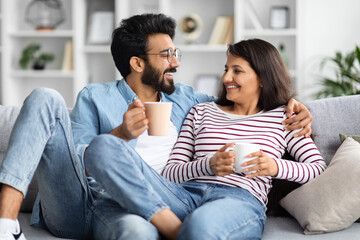 Relaxed hindu young lovers drinking coffee at home