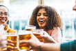© Nicolas Micolani - Multiracial friends enjoying beer at brewery pub- Group of happy people toasting  glasses sitting  at table  bar and having fun- Lifestyle Food and beverage Concept with diverse guys and girls