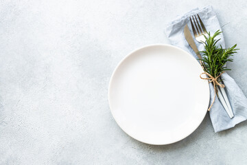 Wall Mural - Table setting, serving on white. White plate, cutlery and napkin. Flat lay image with copy space.