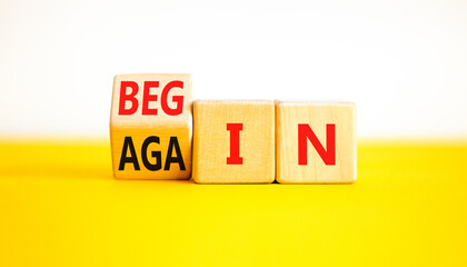 Wall Mural - Begin again symbol. Businessman turns wooden cubes and changes the word begin to again. Beautiful yellow table white background. Business and begin again concept. Copy space.