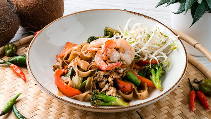 Wall Mural - Udon noodles with shrimp, chicken, carrots, onions, broccoli, sweet peppers and green sprouts.