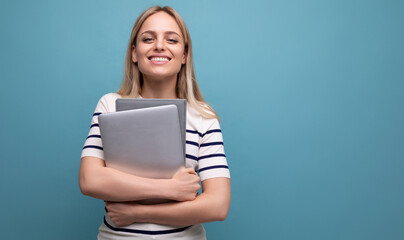 smart successful confident girl student with a laptop in her hands on a blue isolated background