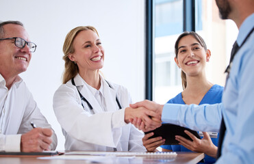 Sticker - the medical world is bigger than I thought. Shot of two doctors shaking hands in a meeting at a hospital.