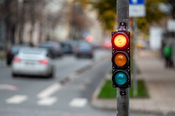 Wall Mural - view of city traffic with traffic lights, in the foreground a traffic light with a red light