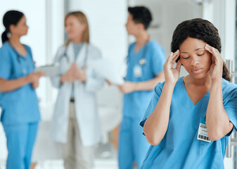 Wall Mural - Headaches can get to anyone. Shot of a medical practitioner looking stressed in the middle of a meeting in hospital.