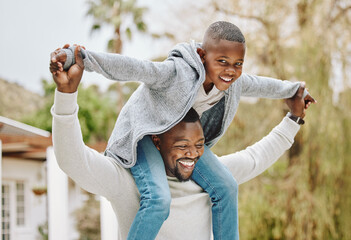 Canvas Print - My dad is stronger than your dad. Cropped portrait of an adorable little boy sitting on his fathers shoulders outside.