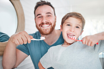 Wall Mural - Were on top of our oral hygiene. Shot of a little boy and his father brushing their teeth together at home.