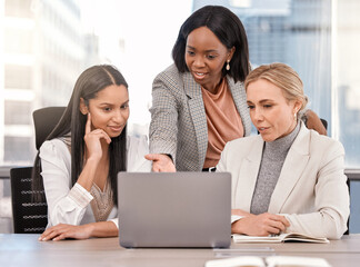 Fototapete - Days like these are what I live for. Shot of a group of businesswomen working together while using a laptop.