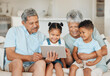 © K Abrahams/peopleimages.com - The memories we make with our family is everything. Shot of grandparents bonding with their grandchildren and using a digital tablet on a sofa at home.