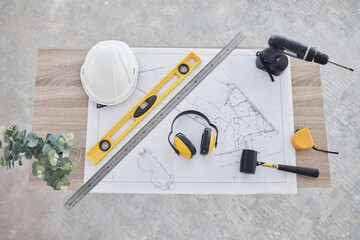 Sticker - Ready to begin. High angle shot of building plans and equipment on a table in an empty living room during the day.