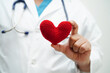 © manassanant - Asian woman doctor holding red heart for health in hospital.