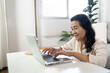 © Charlie's - Middle age Asian woman Work from home. senior woman smiling Beautiful mature asian woman on laptop with technology concept
