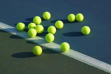 Wall Mural - Come on, toss one. Shot of an empty tennis court and tennis balls during the day.