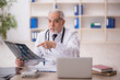 © Elnur - Old male doctor radiologist working in the clinic