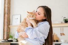 Young Pregnant Woman At Home With Her Red Cat. Pet Owner At Home,