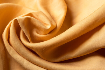 Close up of orange lyocell texture, fashiom cloth fabric swatch, summer .quality clothing