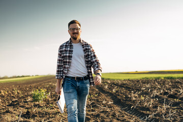 Wall Mural - A happy man is walking in the field on a sunny day.