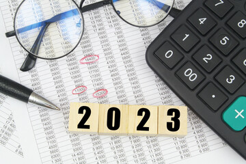 Wall Mural - Round eyeglasses, pen, calculator and cubes with numbers 2023. 