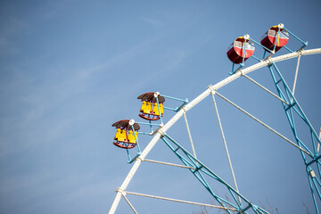 Wall Mural - Ferris wheel, booths against the blue sky.