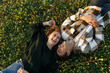 Top view of relaxed young couple lying together on green grass with eyes closed. Relationships and love concept. 