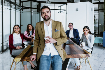 Wall Mural - young latin businessman portrait working with teamwork on background at office in Mexico, hispanic people in Latin America