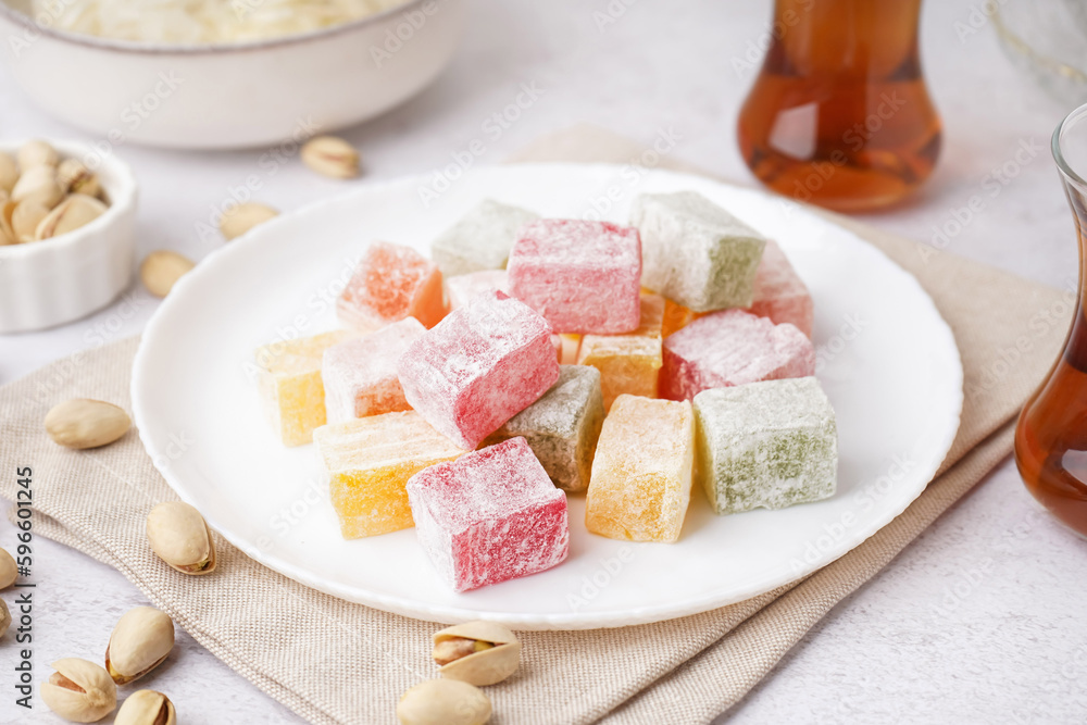 Plate with tasty Turkish Delight on light background