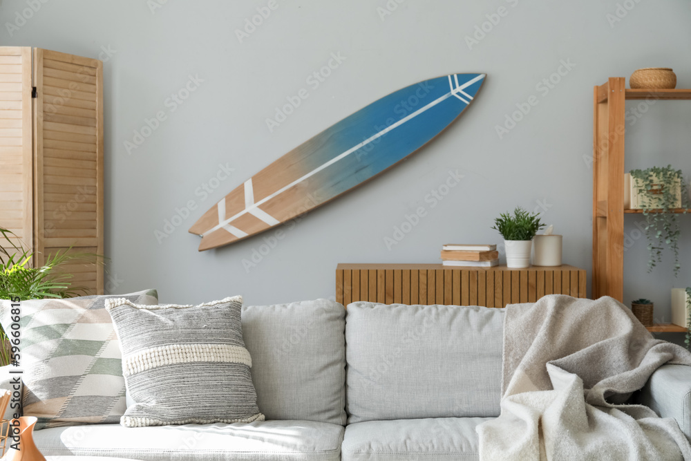 Surfboard hanging on light wall in living room