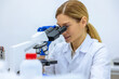 © zinkevych - Scientist looking under microscope, doing analysis of test sample ambitious biotechnology specialist