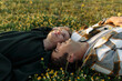 Side view of relaxed young couple lying together on green grass with eyes closed. Relationships concept