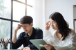 © NINENII - Asian couple sitting at table at home, using laptop to check documents overdue bills, taxes, debt due, bank account balance.lack of money bankruptcy, financial problems concept.