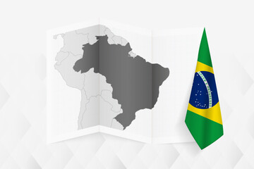 Sticker - A grayscale map of Brazil with a hanging Brazilian flag on one side. Vector map for many types of news.