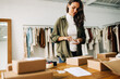 © (JLco) Julia Amaral - Business woman processing a package for dropshipping using a mobile scanner app