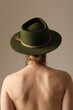© face_reader_img - Back view young woman wearing green hat posing indoor. Vertical mock-up.