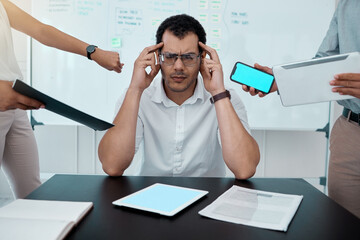 Wall Mural - Please go away. Shot of a young businessman looking stressed out while working in a demanding office environment.