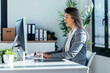 © nenetus - Attractive smart business woman working with computer in a modern office.
