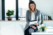 © nenetus - Beautiful elegant business woman working while reading some notes sitting on the desk at modern office