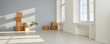 © Studio Romantic - Interior of new house or apartment on moving day. Empty living room with white and light gray walls, unpacked cardboard boxes, green plant and laminate flooring. Banner background. Real estate concept